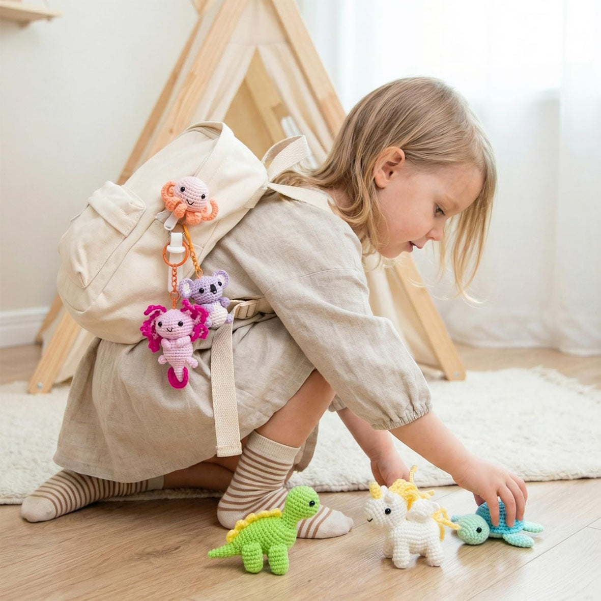 Child playing with colorful toys on a wooden floor with a teepee in the background