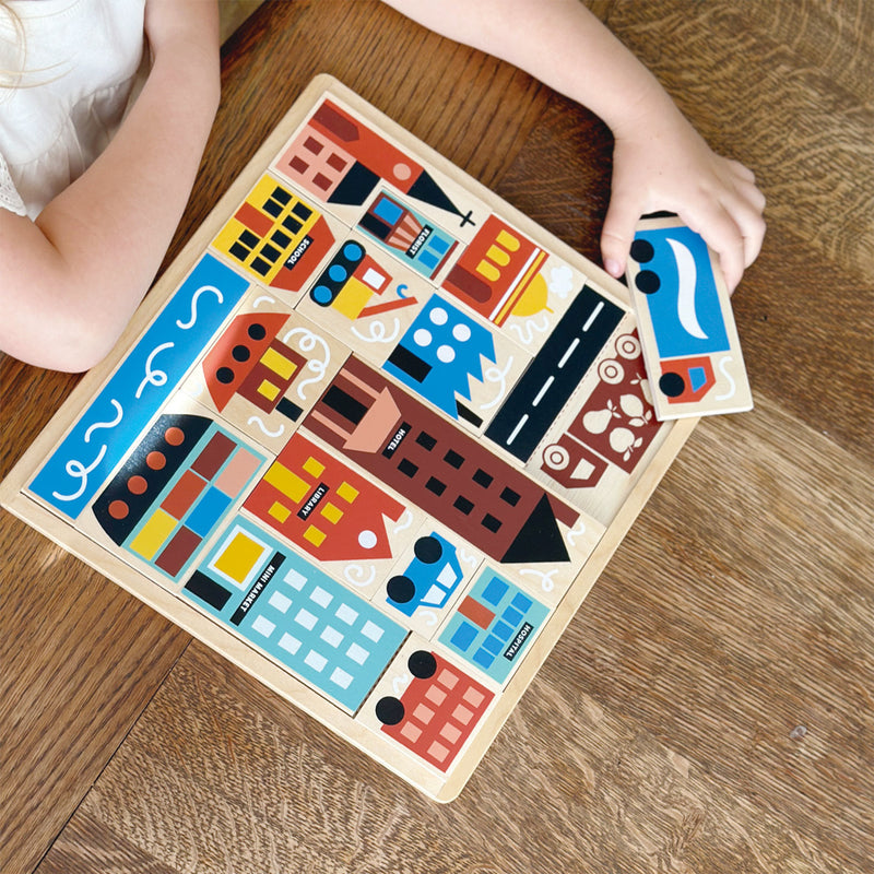 Child playing with mentari wooden town blocks puzzle on a wooden floor